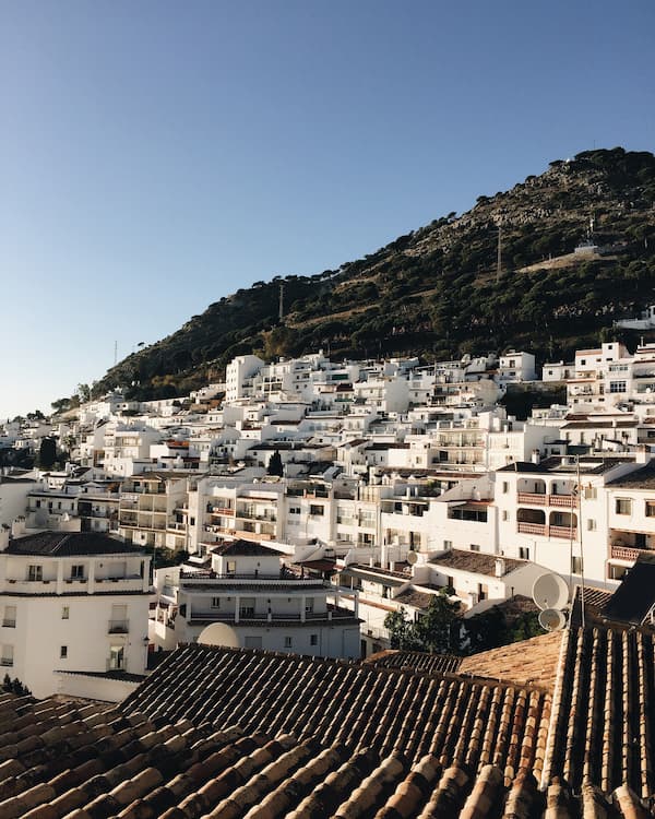 White buildings on hillside under blue sky
